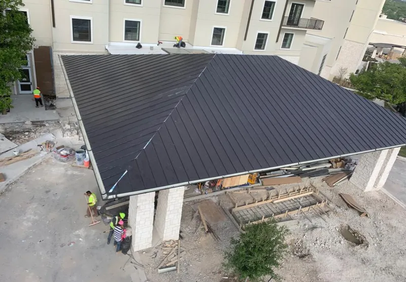 Metal roofing installation team working on a commercial building in Forsyth